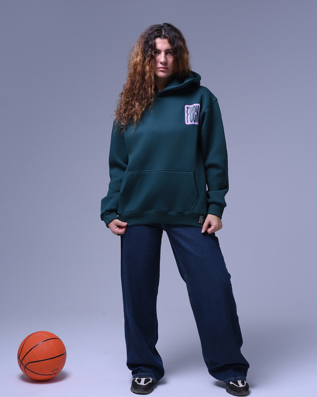 Model wearing dark green oversized hoodie for unisex with front pocket paired with loose dark blue pants