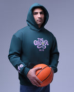 Man wearing green oversized hoodie for women by NotYourSize2025 holding a basketball