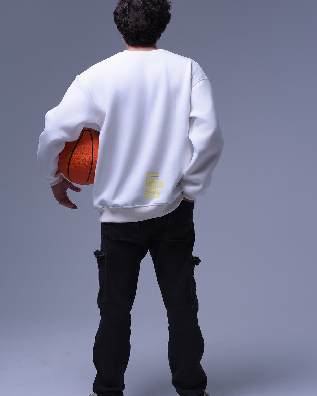 Back view of man wearing white oversized crewneck sweatshirt holding basketball by NotYourSize2025