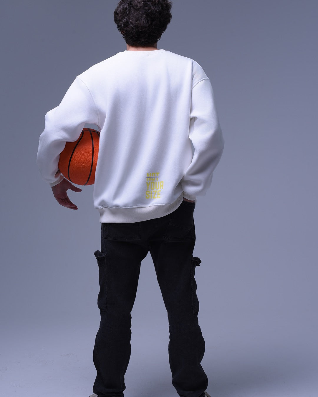 Back view of man wearing white oversized crewneck sweatshirt holding basketball by NotYourSize2025