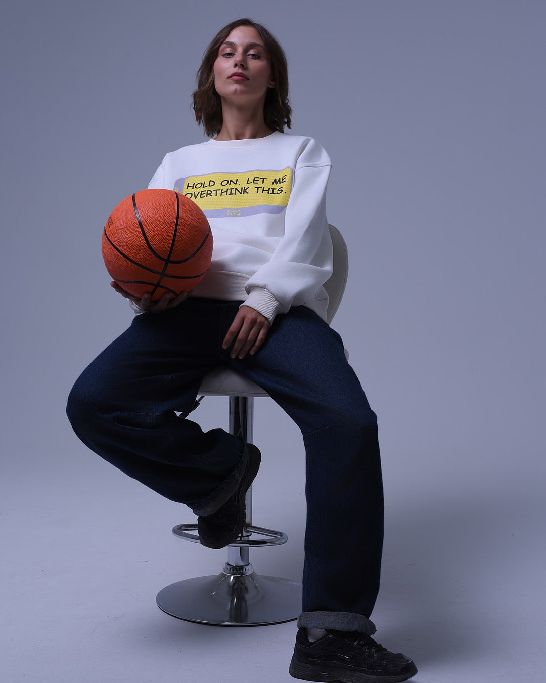 NotYourSize2025 oversized crewneck sweatshirt white with yellow text worn by woman holding basketball