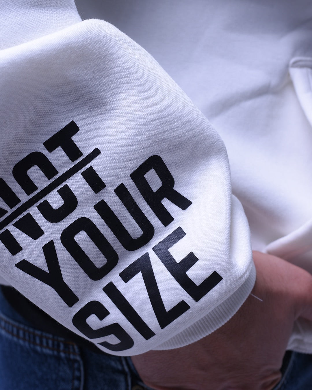 Close-up of nys oversized hoodie for women with bold black text on white fabric sleeve